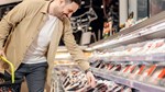 Man shopping for beef at grocery store retail counter